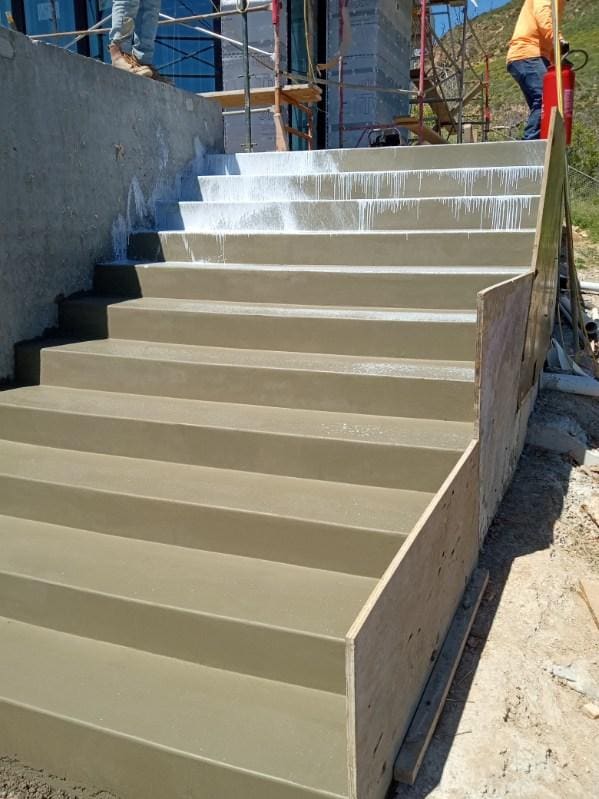 Finished commercial concrete stairway under construction with scaffolding