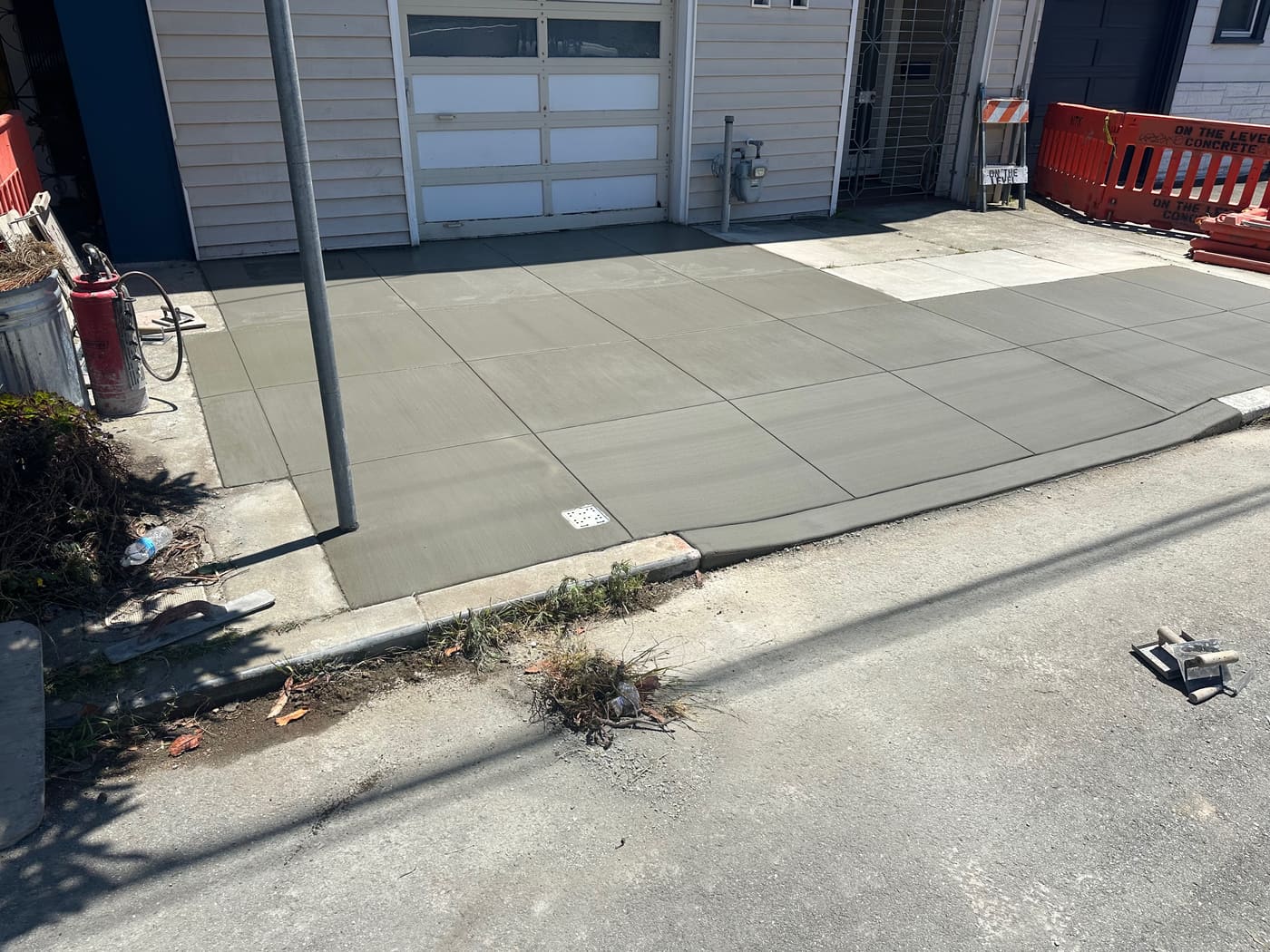 New concrete driveway apron in front of a garage