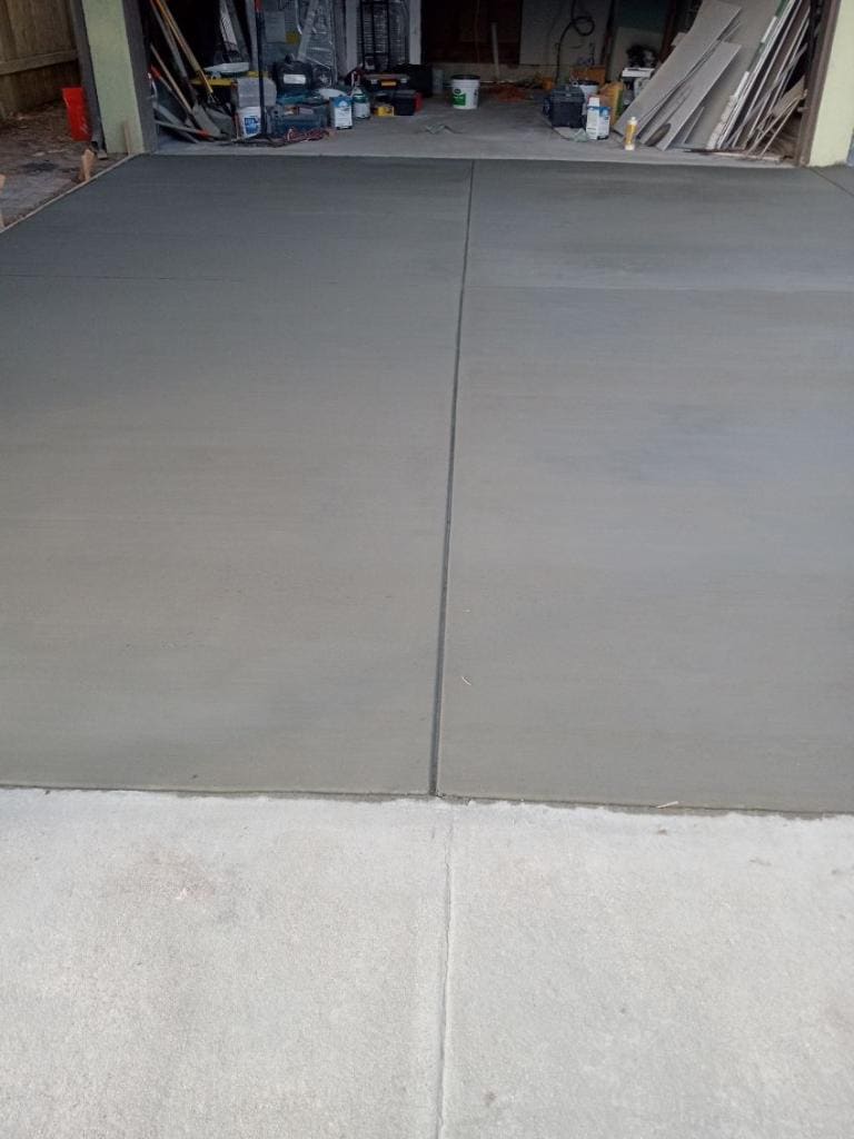 Freshly poured concrete driveway slab with clean control joints