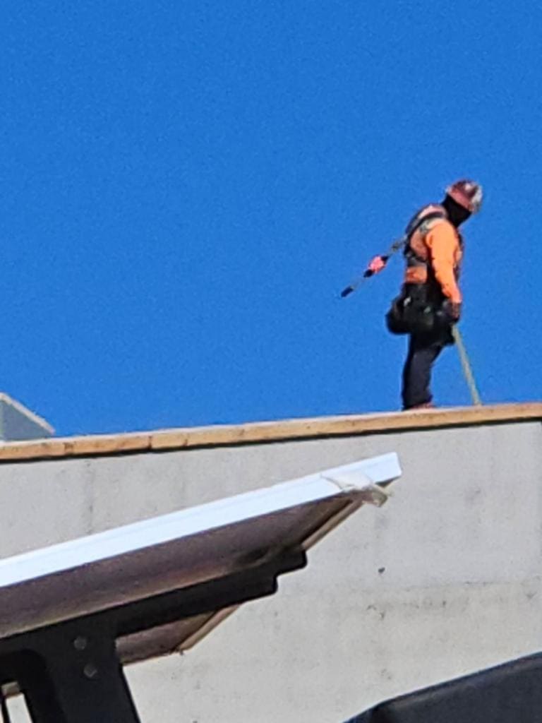 Crew member pouring concrete on a federal building rooftop
