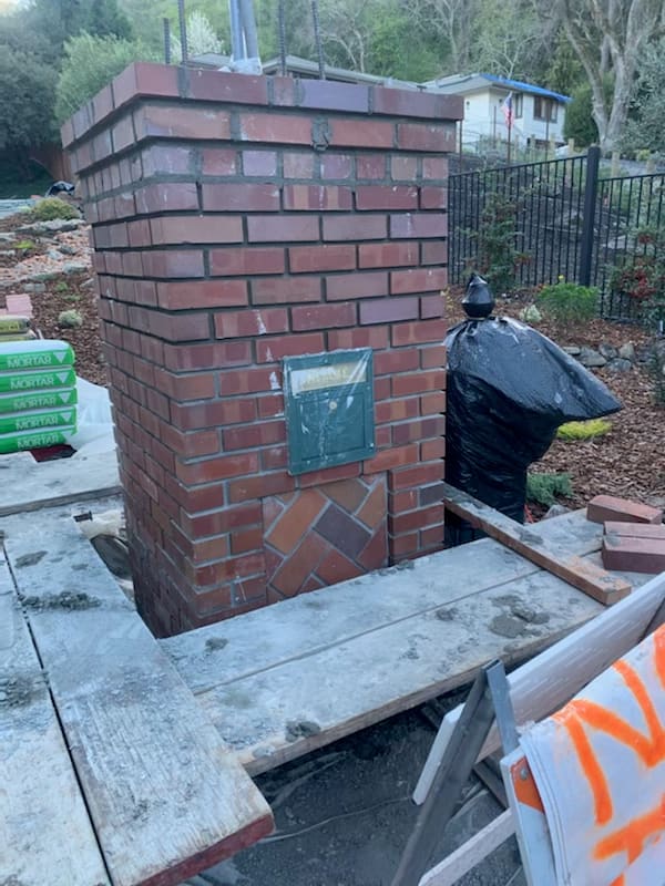 Brick column being built with a concrete cap
