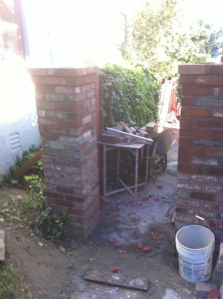Custom brick masonry pillars framing a side yard