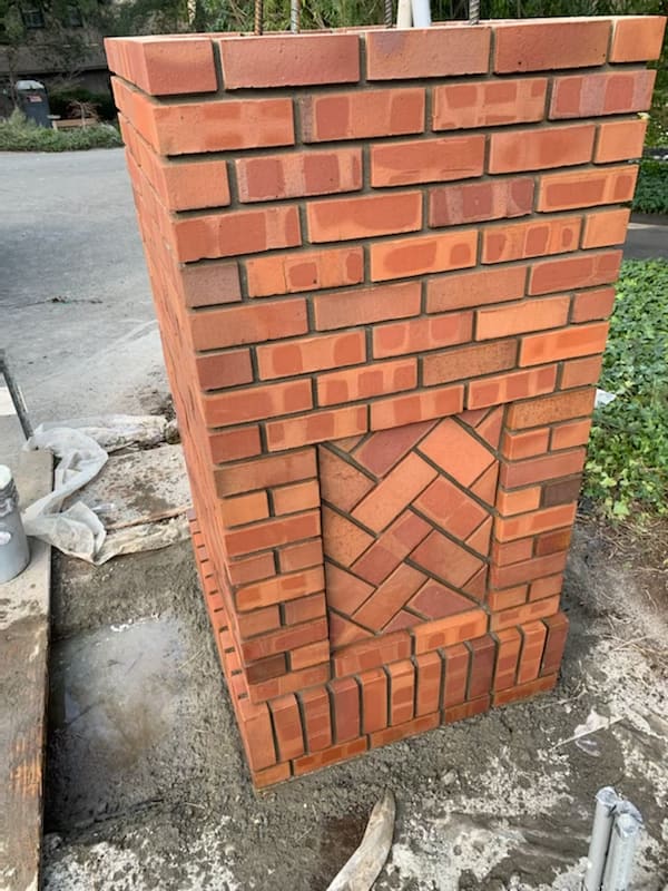 Brick pillar with a herringbone pattern inset