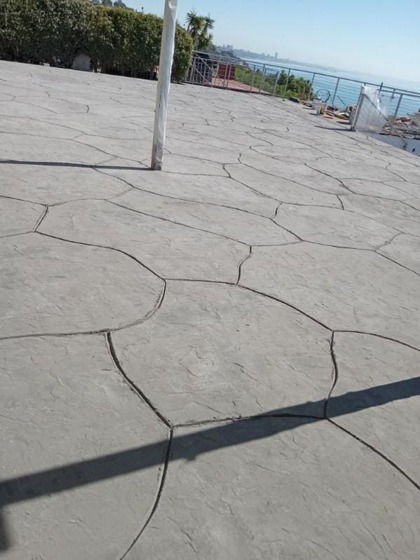 Stamped concrete patio finished in an irregular flagstone pattern overlooking the bay