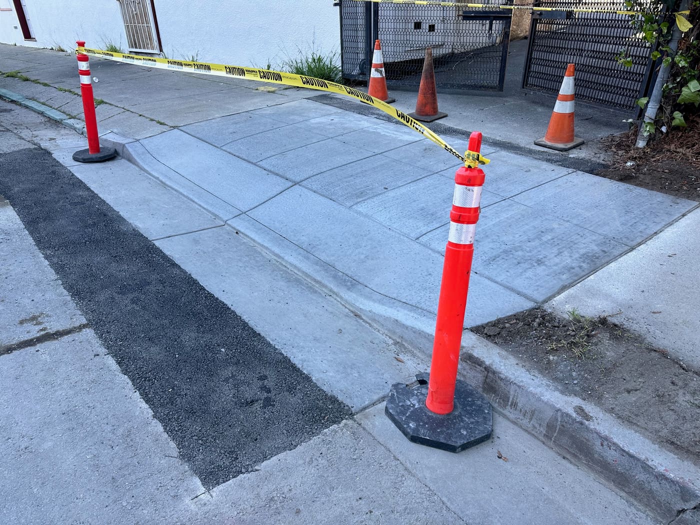 Freshly poured sidewalk panel with safety cones