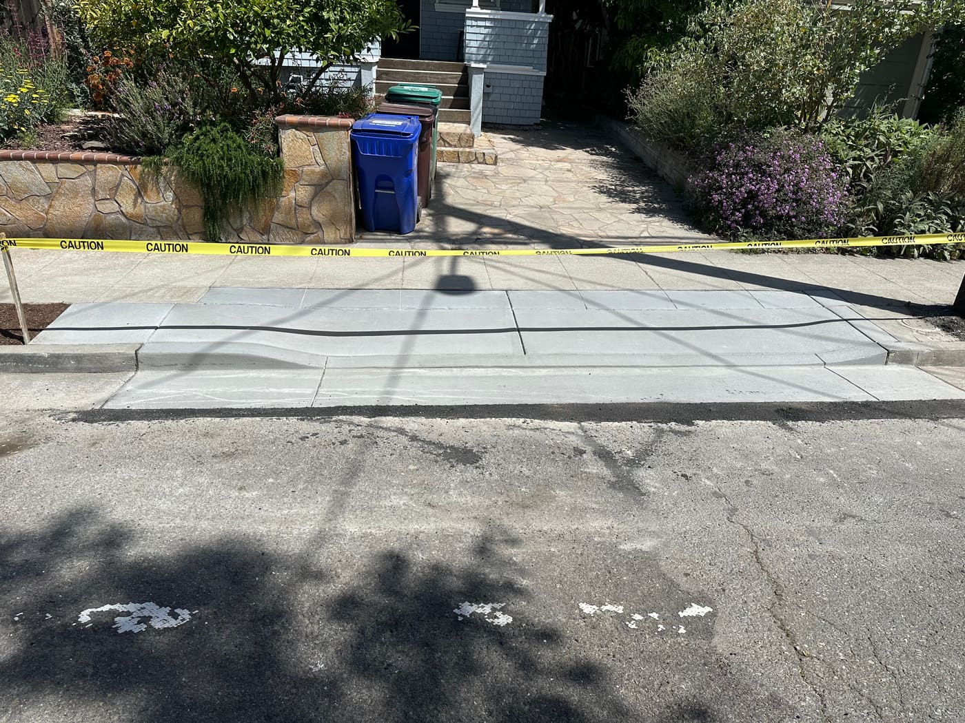 New concrete sidewalk panel poured across a driveway crossing