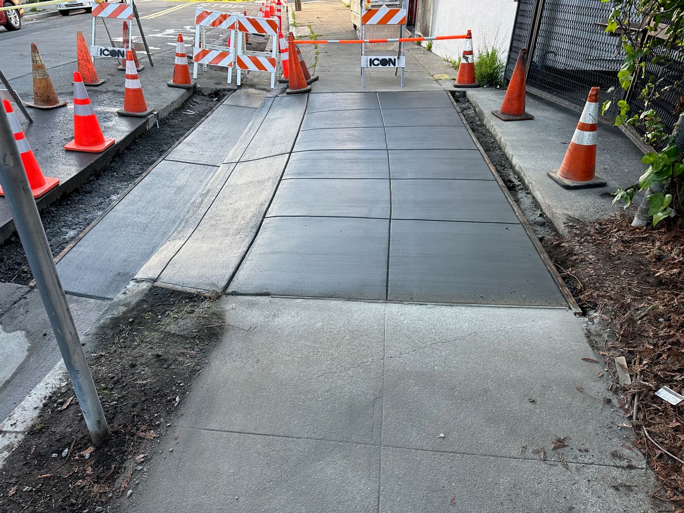 New sidewalk panels poured with safety barricades in place