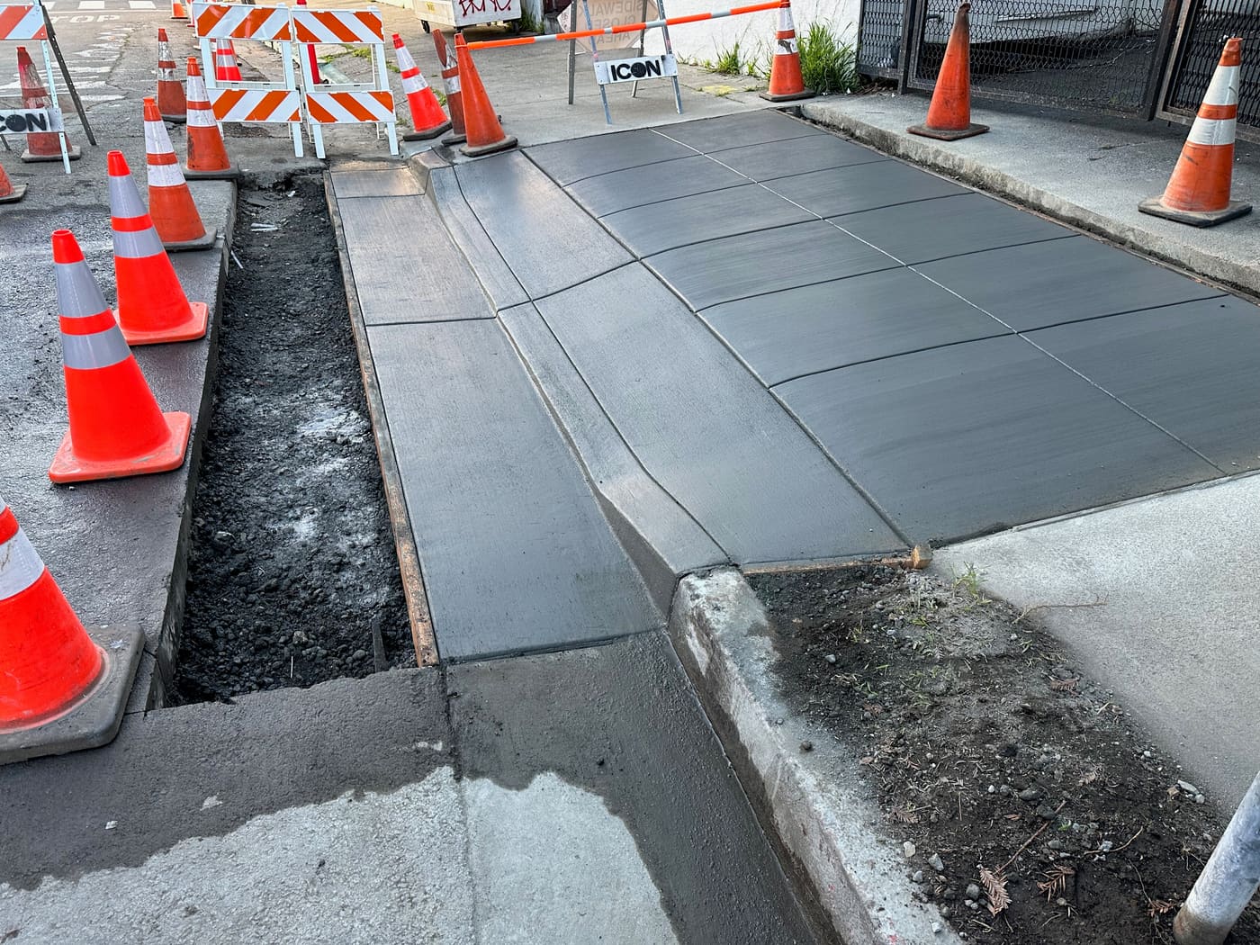 Charcoal colored concrete sidewalk poured near a building entrance