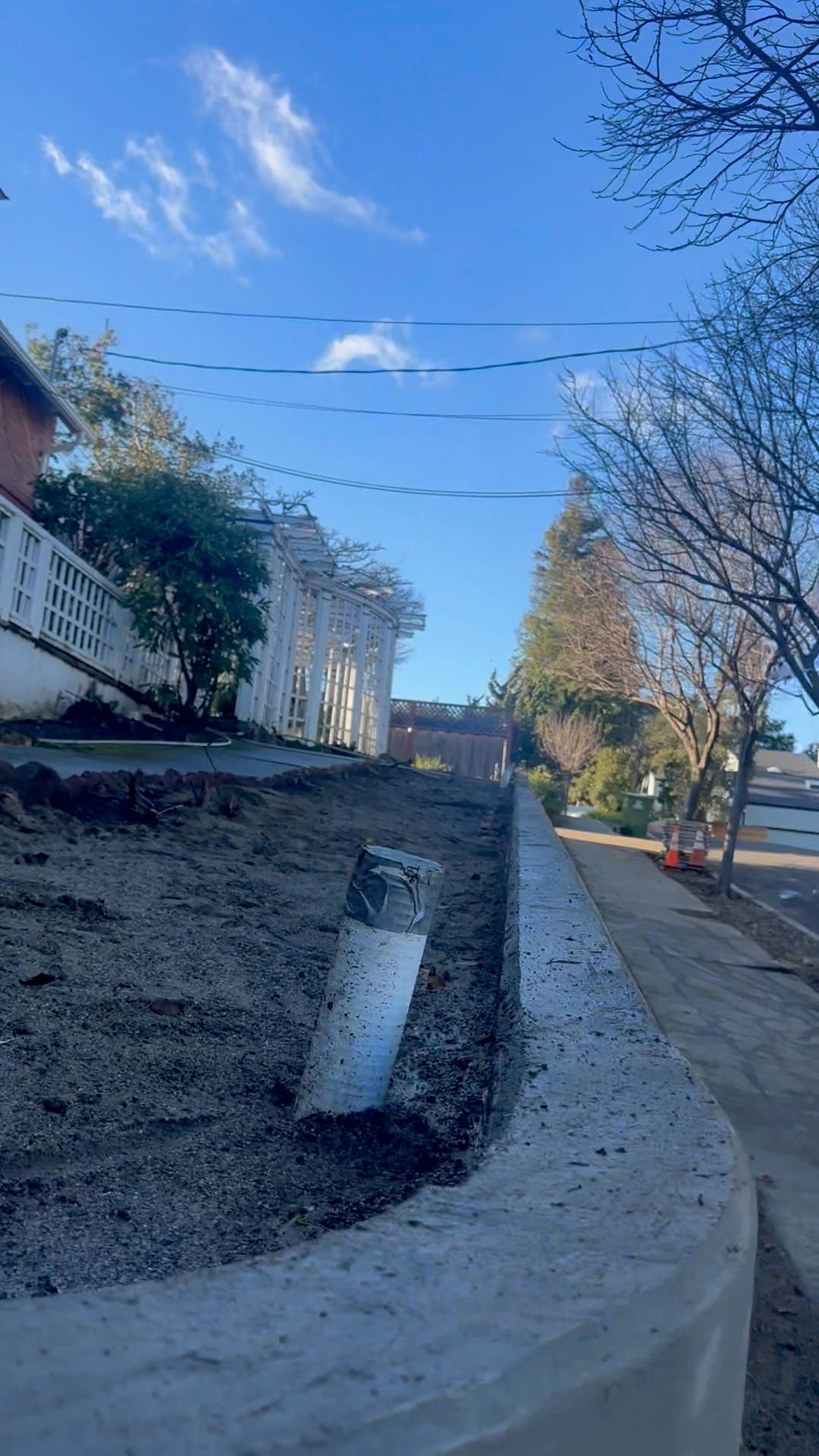 Low concrete retaining wall formed along a sloped hillside path