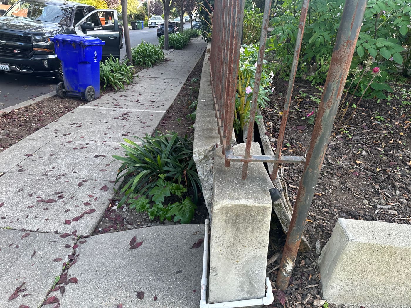 Retaining wall corner post with reinforcement and a metal fence