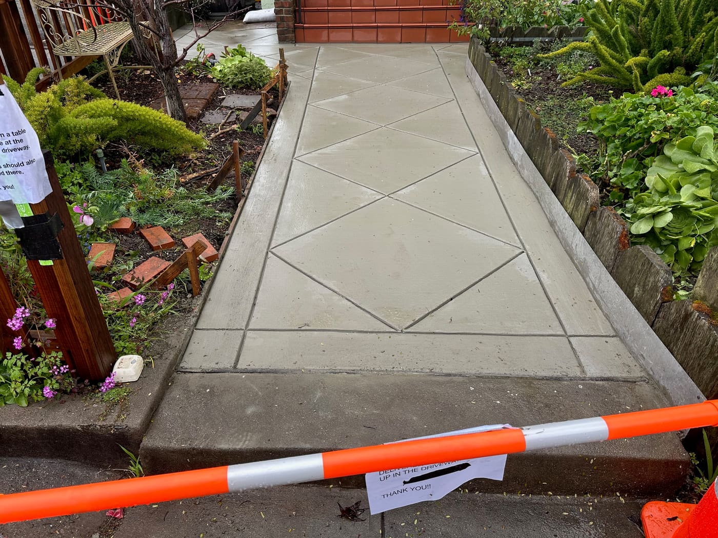 Concrete walkway with a diamond scoring pattern through a garden