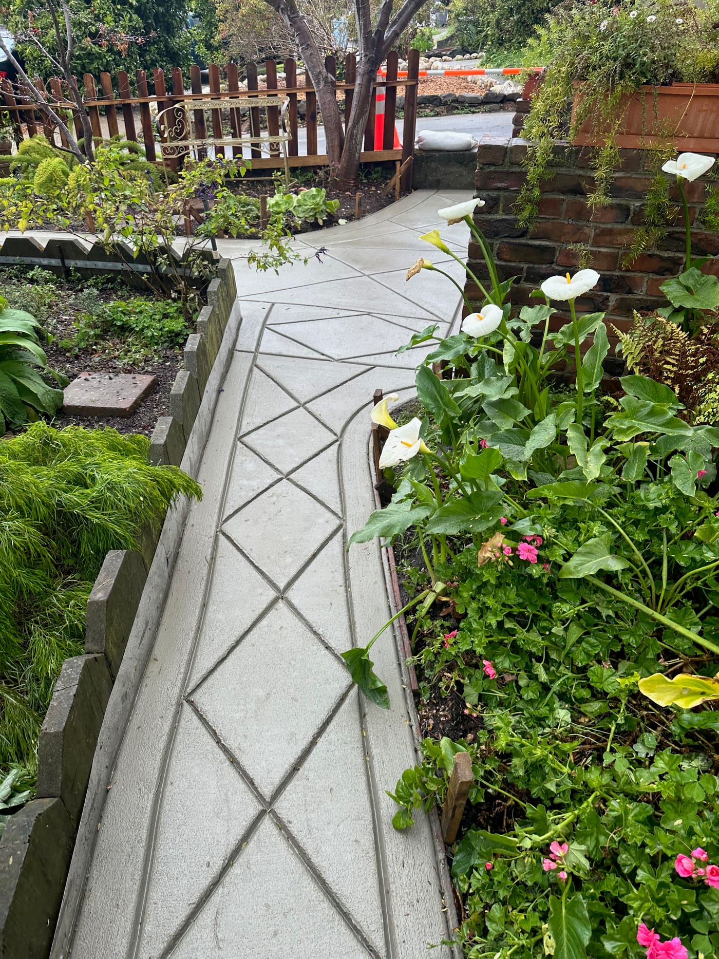 Decorative diamond-scored concrete path through flower beds