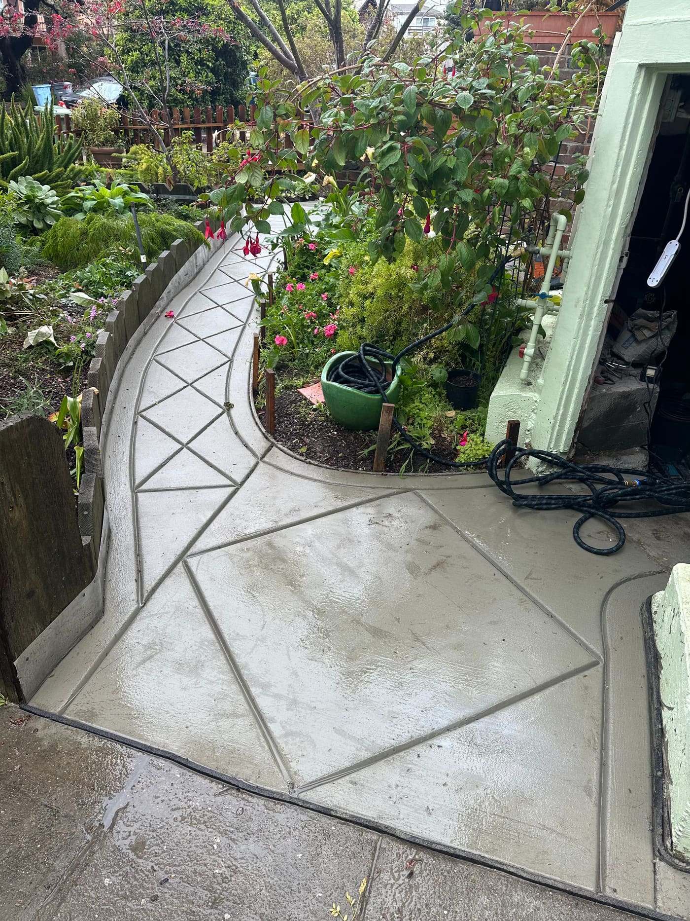 Decorative diamond-pattern concrete walkway through a garden entrance